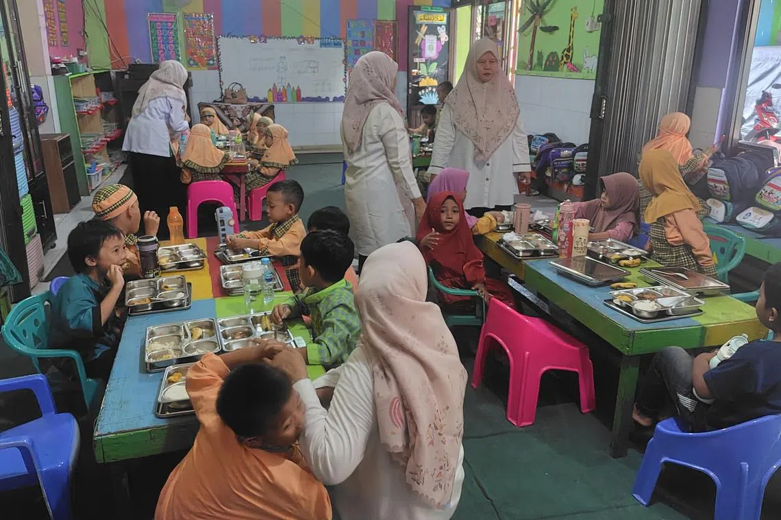 Students at Al-Marzuqiyah kindergarten in East Jakarta enjoy their government-bankrolled free lunch during a class break. 