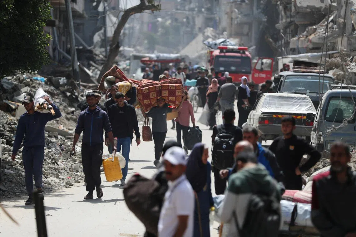 Palestinians make their way with belongings as they flee their homes, after the Israeli army issued evacuation orders, in the Shujaiya neighborhood of Gaza City, April 3, 2025. REUTERS/Mahmoud Issa