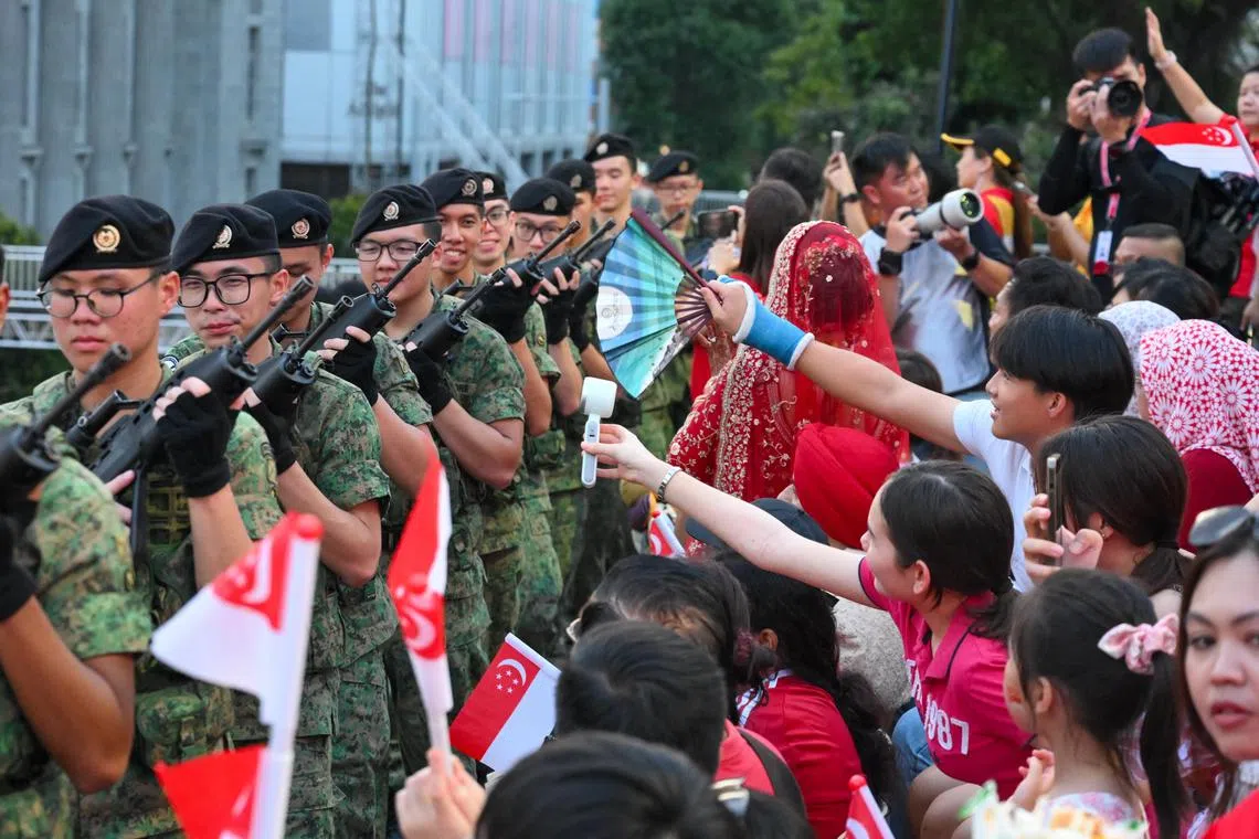 Parade attendees fanning  soldiers as they march through the stands as part of an Onward March segment that took the parade and ceremony closer to the audience.