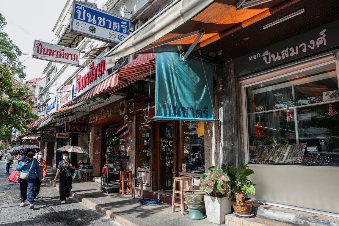 People walk past gun shops in Bangkok’s historic gun district.