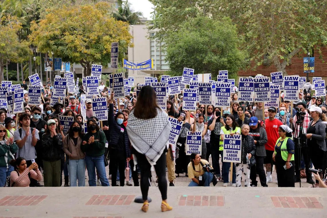 Unionised academic workers, upset about the University of California's response to pro-Palestinian protests at various campuses, hold placards as they strike at the University of California Los Angeles in Los Angeles, California, on May 28. 