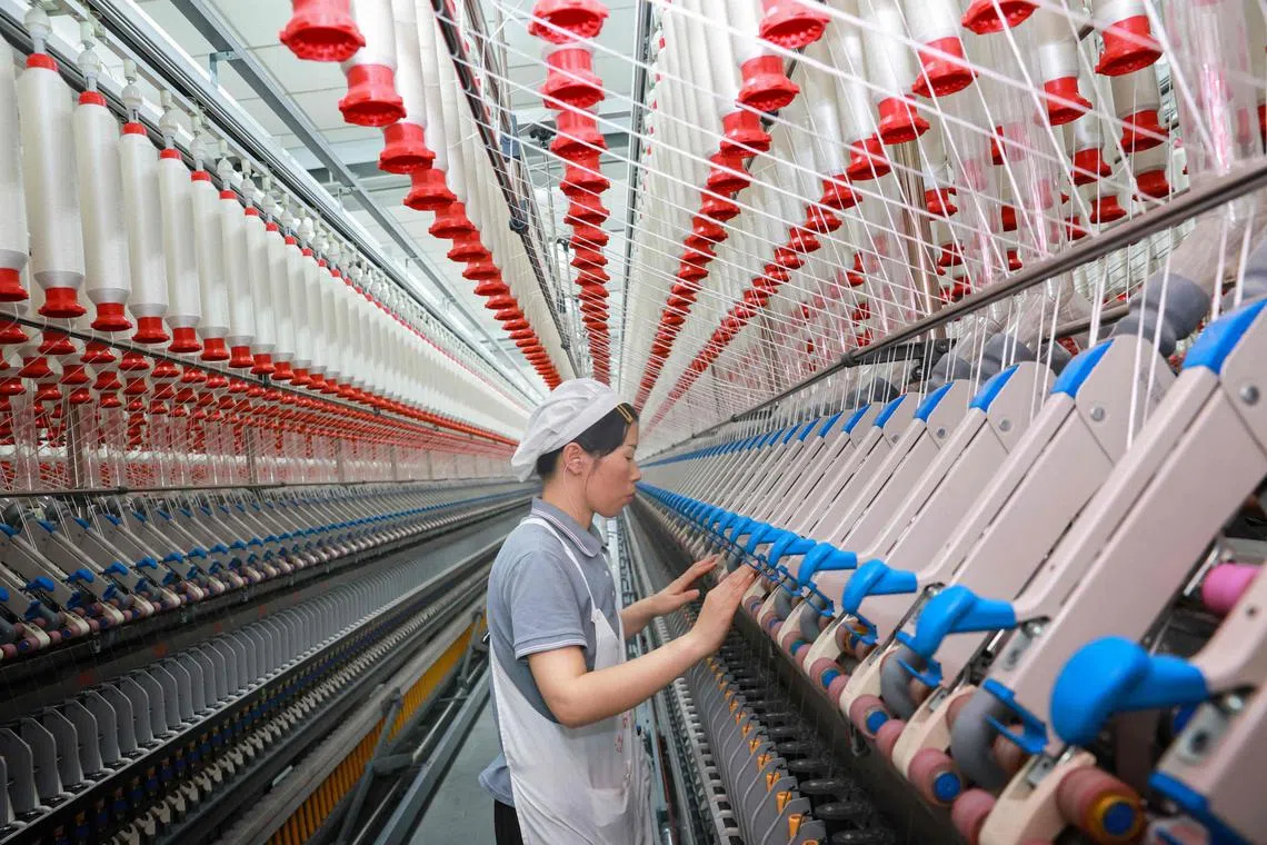 A worker operates machines at a textile factory in Nantong, in eastern China's Jiangsu province.