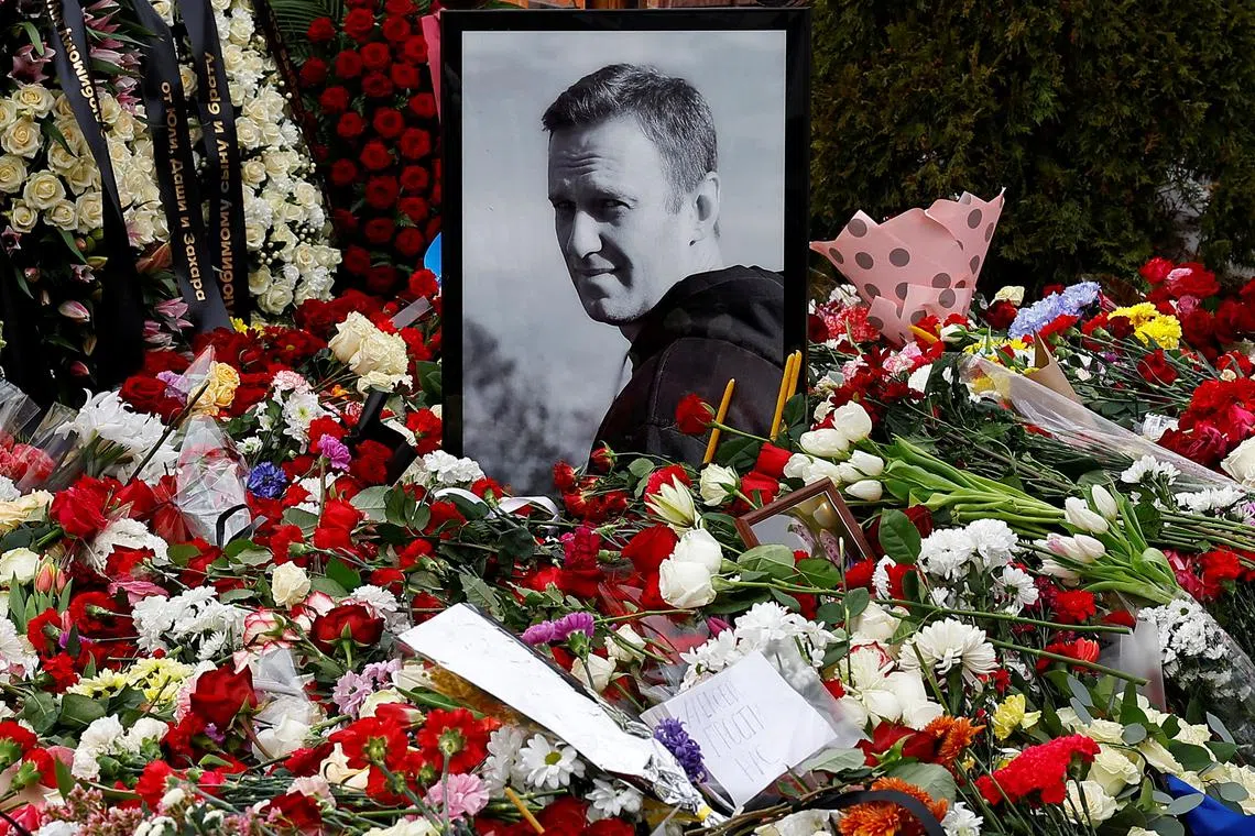 A portrait of Russian opposition politician Alexei Navalny is placed amid flowers at his grave the day after the funeral at the Borisovskoye cemetery in Moscow, Russia, March 2, 2024. REUTERS/Stringer/ File Photo