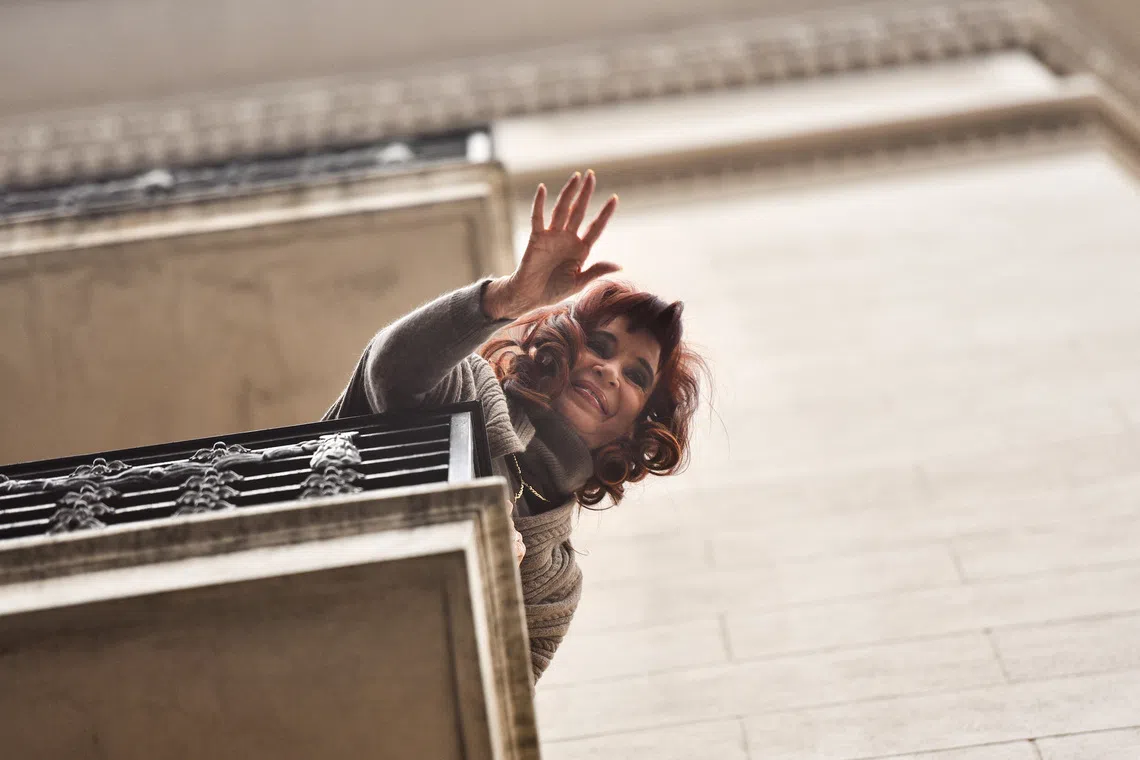 Former Argentinian President Cristina Fernandez de Kirchner gestures from the balcony of her home after Argentina's Supreme Court upheld her guilty verdict for defrauding the state, in Buenos Aires, Argentina, June 16, 2025. REUTERS/Pedro Lazaro Fernandez