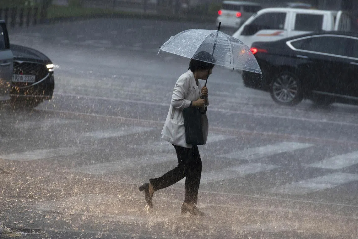epa11482923 A woman walks with an umbrella amid heavy rains at Gwanghwamun Square in Seoul, South Korea, 17 July 2024.  EPA-EFE/JEON HEON-KYUN