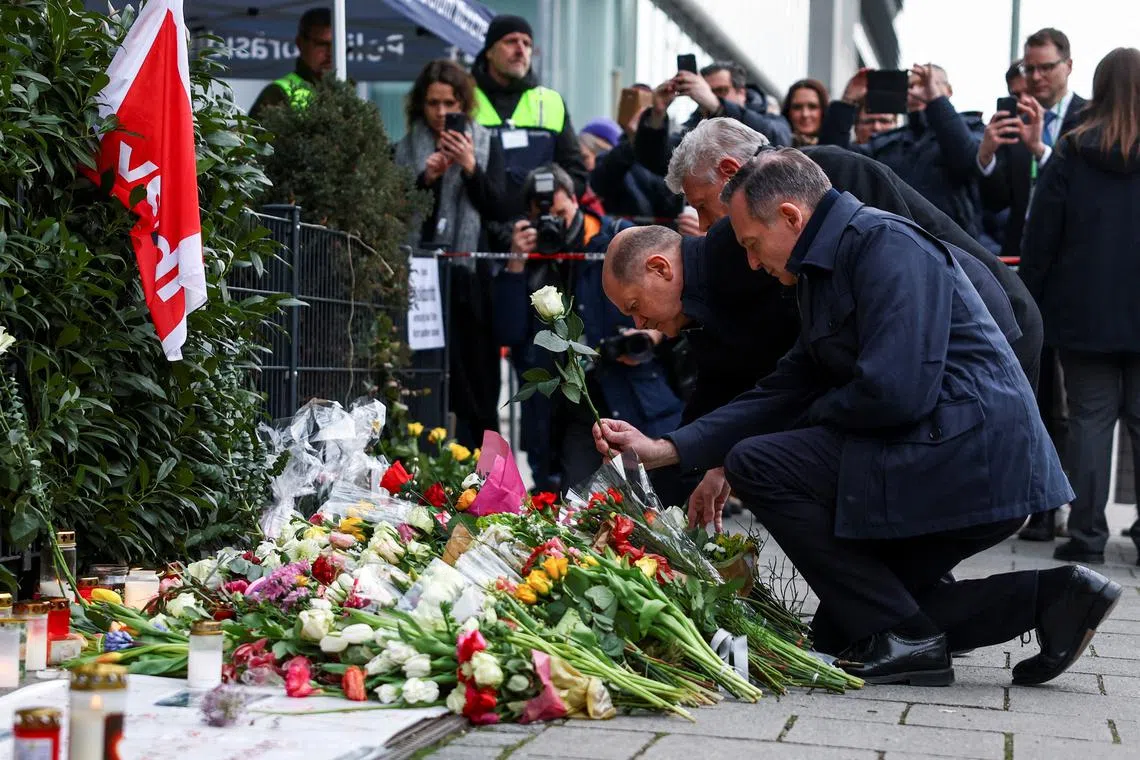 German Chancellor Olaf Scholz, Minister for Justice and Transport Volker Wissing and Munich mayor Dieter Reiter lay flowers as they visit a makeshift memorial for the victims of a suspected ramming attack where a 24-year-old Afghan asylum seeker drove a car into a crowd, as the Munich Security Conference (MSC) takes place in Munich, Germany February 15, 2025. REUTERS/Kai Pfaffenbach
