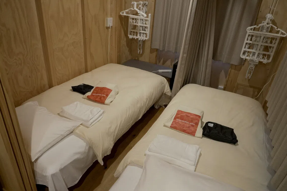 Beds and household goods are prepared inside wooden container-style huts built to house athletes at Athletes Plaza of Aichi-Nagoya Asian Games 2026 in Nagoya, central Japan, September 27, 2026.  REUTERS/Irene Wang
