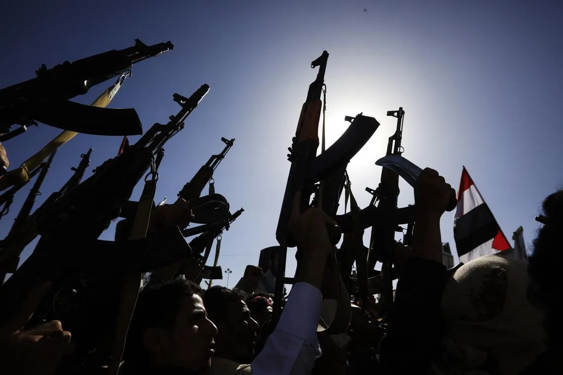 Houthi supporters hold up weapons during a protest in Sana'a, Yemen, on June 7.