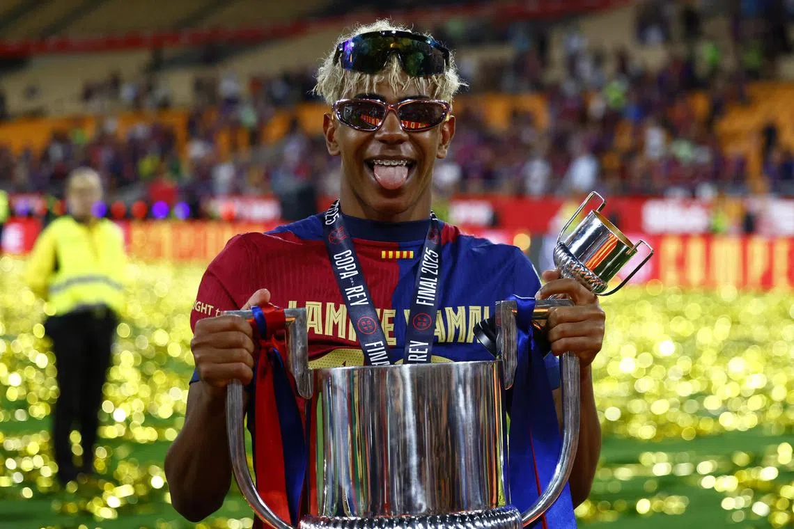 Barcelona's Lamine Yamal celebrates with the trophy after winning the Copa del Rey.