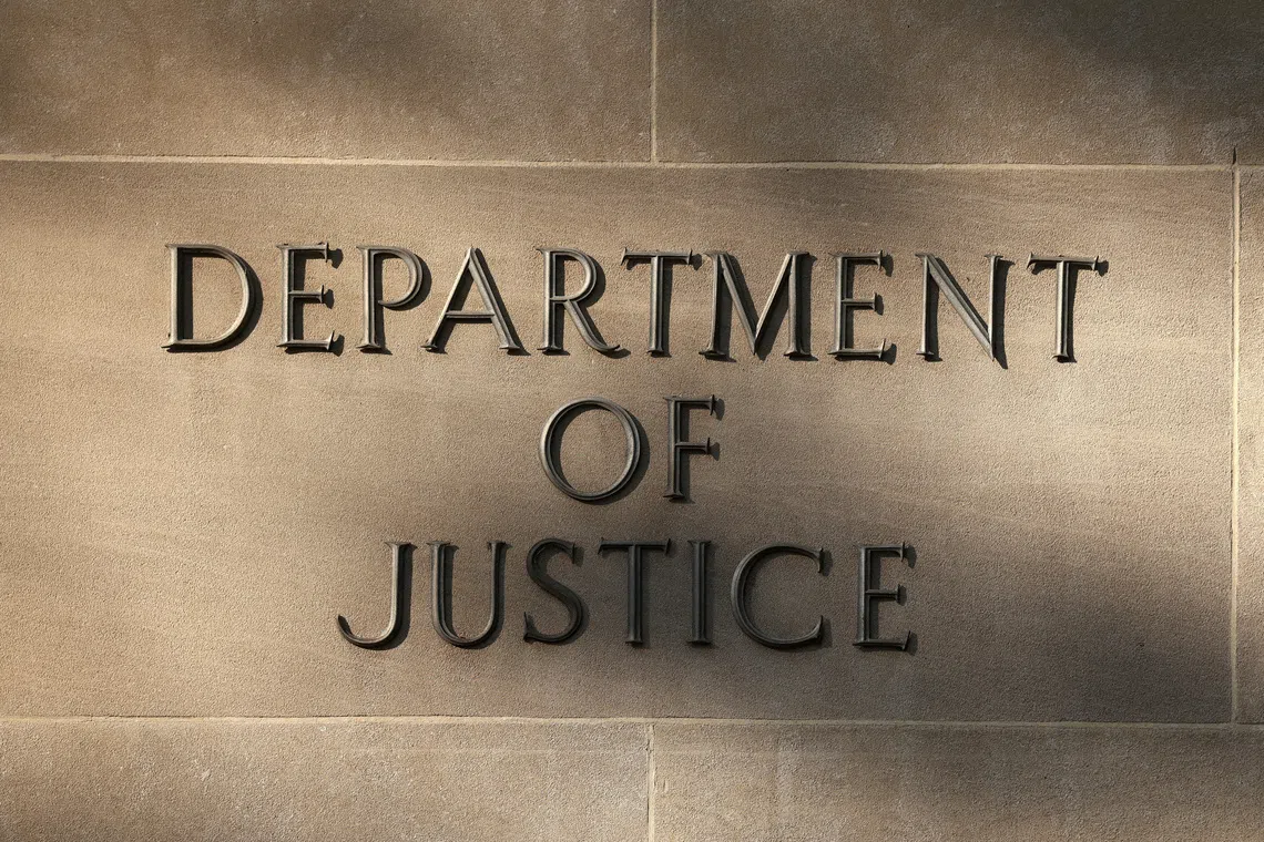 Shadows are cast on a sign at the Department of Justice building in Washington, D.C., U.S., September 23, 2025. REUTERS/Kevin Lamarque