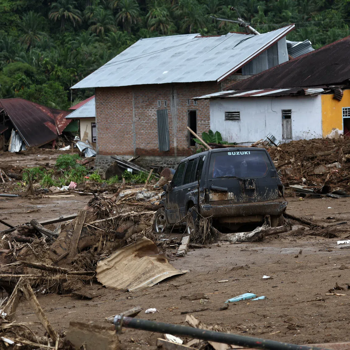 A car stuck in the mud sits among debris at an area hit by deadly flash floods following heavy rains in Palembayan, Agam regency, West Sumatra province, Indonesia, December 2, 2025. REUTERS/Willy Kurniawan