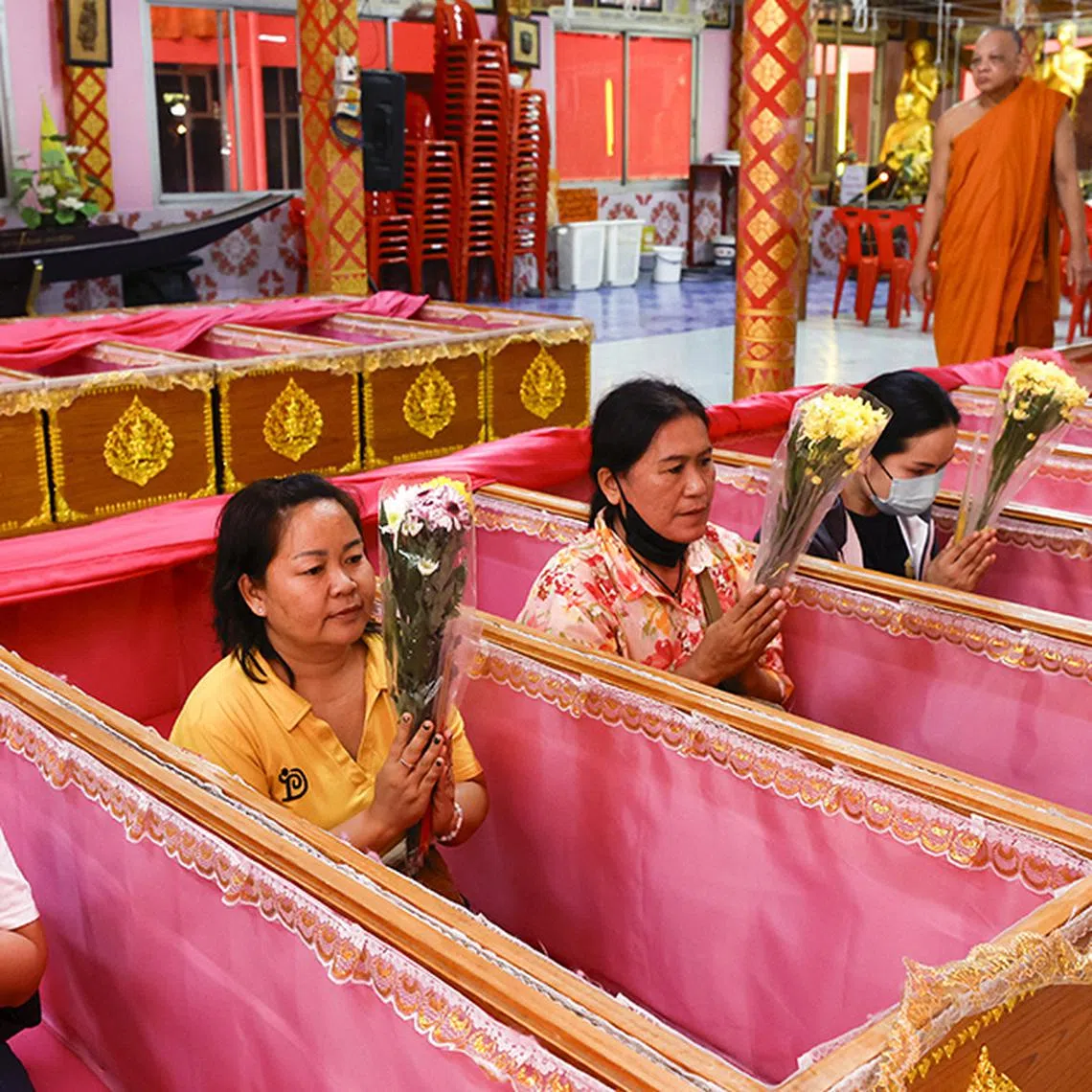 epa11801130 Thai people pray inside coffins as a Buddhist monk performs a rite during the New Year's resurrection ceremony at Wat Takien temple in Nonthaburi province, on the outskirts of Bangkok, Thailand, 01 January 2025. The resurrection ceremony rituals are performed at a Buddhist temple where Thai devotees lie in coffins symbolizing the concepts of death and rebirth in hopes of ushering in a new year filled with luck and the fulfillment of their wishes.  EPA-EFE/RUNGROJ YONGRIT