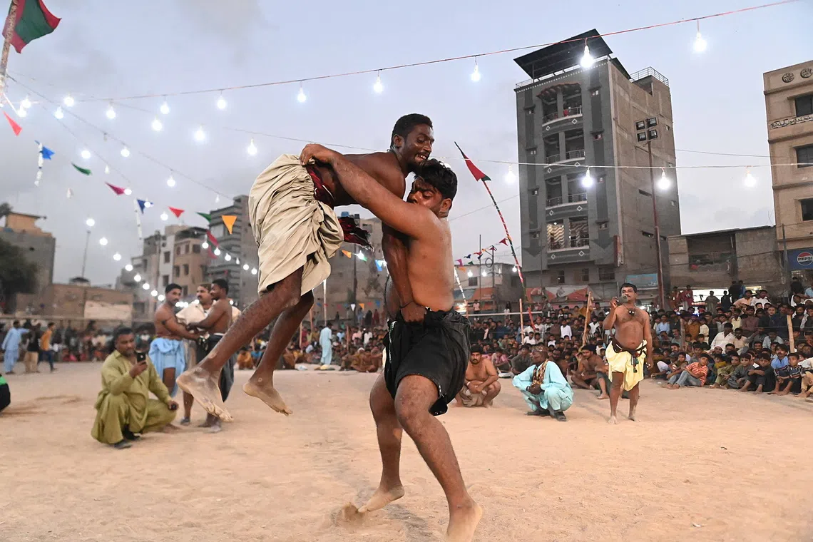 epa13296905 Wrestlers in action during a traditional Sindhi Malakhra wrestling event in Karachi, Pakistan, 11 October 2026. During a Malakhra match, both wrestlers tie twisted cloth around their opponents' waists. They then grab the opponent's waist cloth and attempt to throw him to the ground. EPA/SHAHZAIB AKBER