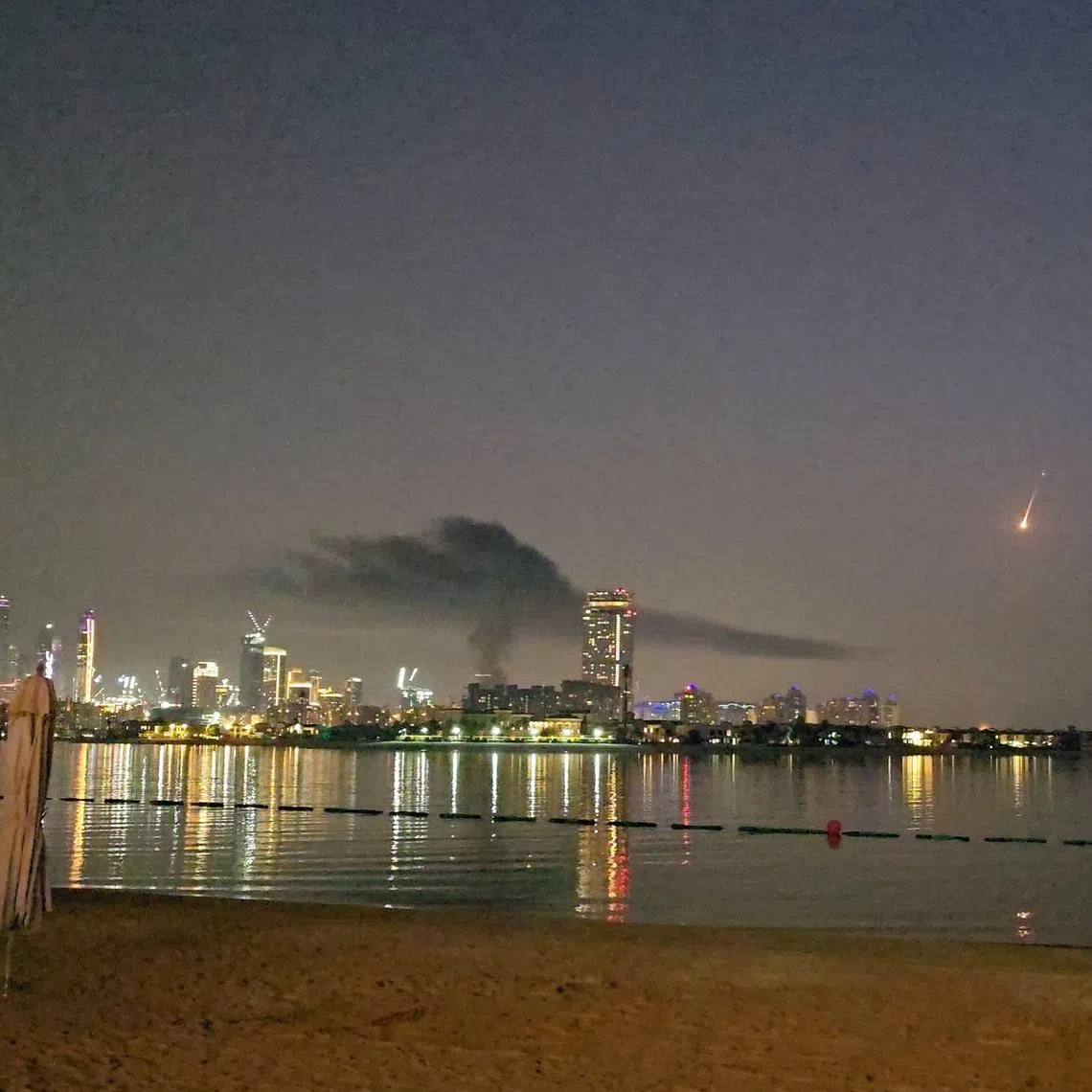 Smoke rises over a hotel damaged in Dubai's famed Palm Jumeirah, in Dubai, United Arab Emirates, on Feb 28.