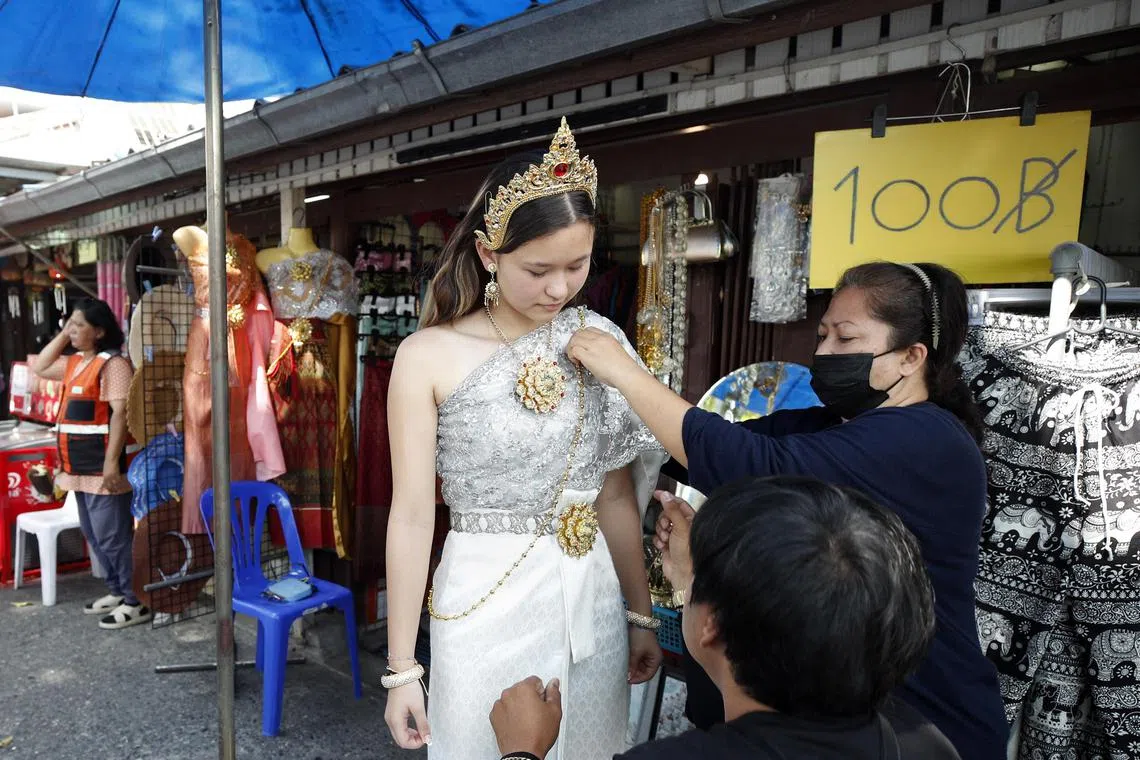 epa10424394 A Chinese tourist dressed in Thai traditional costume rented from a clothing rental shop for a memorial photograph, during a visit to Wat Arun or Temple of Dawn in Bangkok, Thailand, 23 January 2023. Thailand's tourism and business related activities are in recovery stimulated by the influx of Chinese tourists after China lifted COVID-19 travel restrictions. Thailand is projected to welcome five million Chinese visitors in 2023 with 29,4000 tourists from mainland China expected to arrive during Lunar New Year, according to the Tourism Authority of Thailand.  EPA-EFE/RUNGROJ YONGRIT
