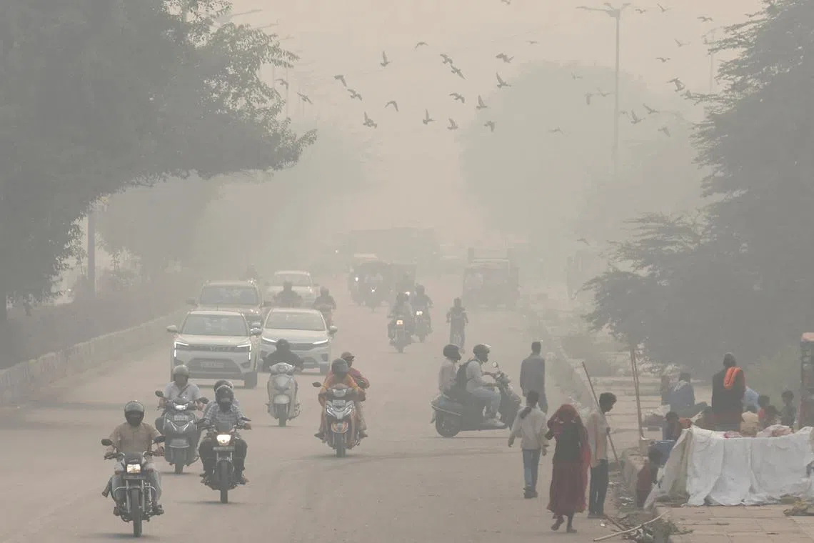 FILE PHOTO: People and vehicles are seen on a road amidst the morning smog in New Delhi, India, November 8, 2023. REUTERS/Anushree Fadnavis/File Photo