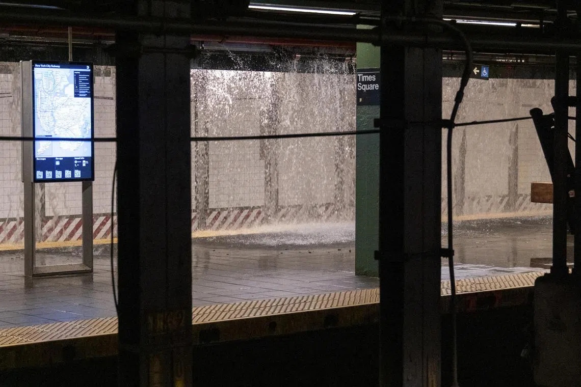 Sheets of water rain down into the Times Square subway station, after a water main installed in 1896 bursts.