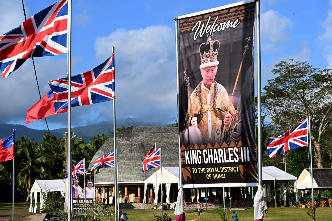 Children play rugby near a portrait of Britain's King Charles III in the village of Siumu on Oct 22.