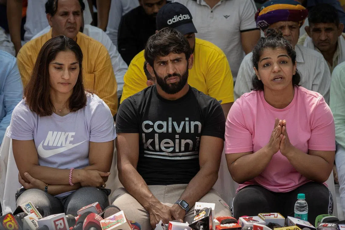 Indian wrestlers (from left) Vinesh Phogat, Bajrang Punia and Sakshi Malik at a sit-in protest demanding the arrest of then Wrestling Federation of India (WFI) chief Brij Bhushan Sharan Singh, who they accuse of sexually harassing female athletes, in New Delhi on April 24, 2023.