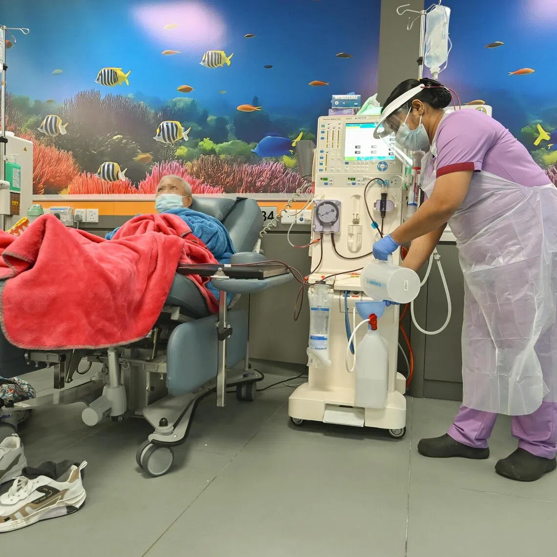 Nurse Chembali Ambujakshan Dhanyamol, tops up the acid concentrate for the Haemodialysis machine, for a patient at NKF. The introduction of the Centralised Acid Concentrate Delivery System system has reduced the need for caregivers to carry the acid concentrate containers, and in turn the medical waste generated.