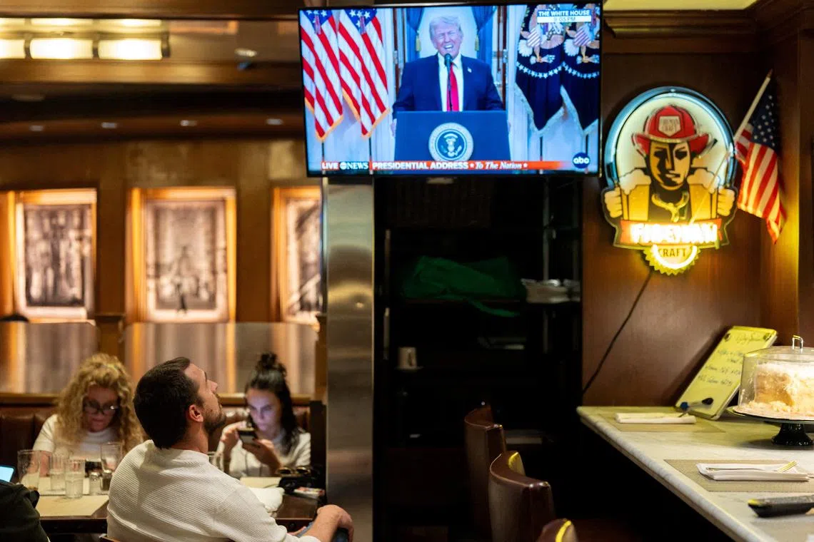 A customer watches U.S. President Donald Trump address the nation on the Iran crisis from the White House in Washington, D.C., on screen at Brooklyn Diner in Times Square, New York, U.S., April 1, 2026. REUTERS/David Dee Delgado/File Photo