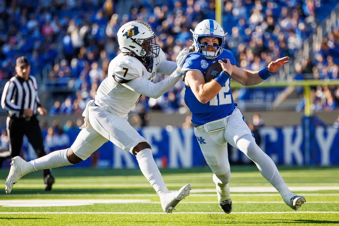 Nov 16, 2024; Lexington, Kentucky, USA; Kentucky Wildcats quarterback Brock Vandagriff (12) is forced out of bounds by Murray State Racers linebacker Justice Cross (7) during the second quarter at Kroger Field. Jordan Prather-Imagn Images