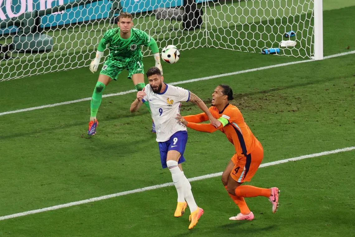 Olivier Giroud of France (centre) in action against the Netherlands' Virgil van Dijk.