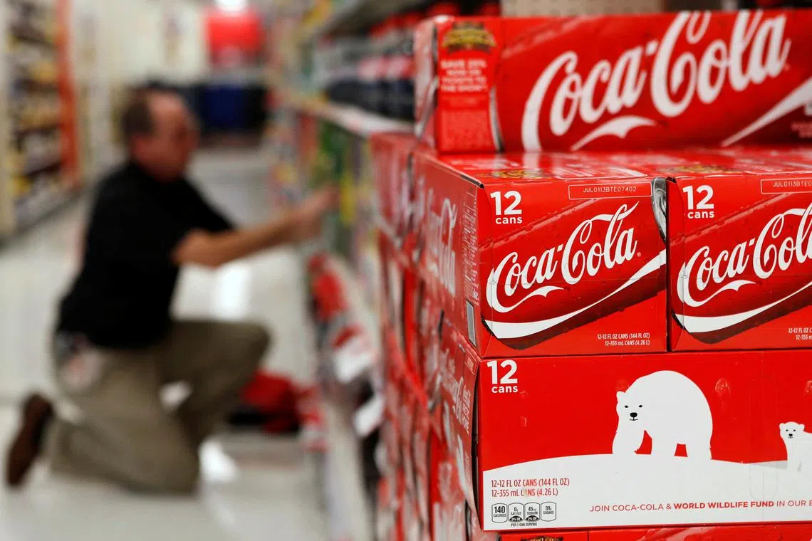 An employee arranges bottles of Coca-Cola at a store in Alexandria, Virginia October 16, 2012. REUTERS/Kevin Lamarque/File Photo