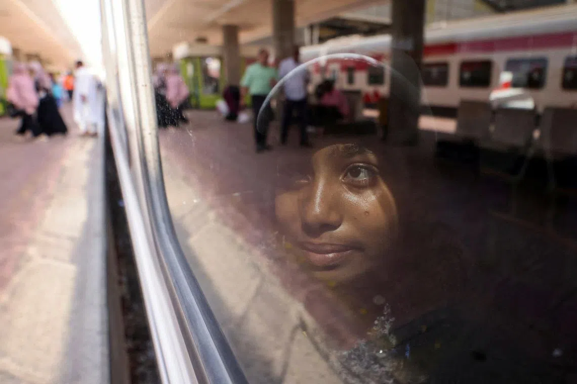 A child looking out from a train window as Sudanese families displaced by conflict return home from Egypt to Sudan, is transported home from Cairo's Ramses Station to Aswan, in Egypt, Cairo, on July 21, 2025. 