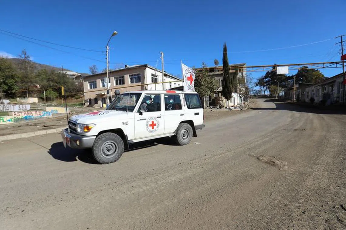 International Committee of the Red Cross (ICRC) members drive an off-road vehicle in Hadrut town, which recently came under the control of Azerbaijan's troops following a military conflict against ethnic Armenian forces and a further signing of a ceasefire deal, in the region of Nagorno-Karabakh, November 25, 2020. Picture taken November 25, 2020. REUTERS/Aziz Karimov/File photo