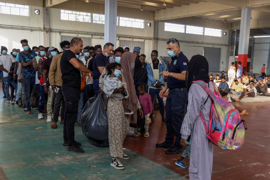 A group of newly-arrived migrants prepare to depart to mainland Greece, from their temporary shelter in a municipal hall in the town of Agyia, on the island of Crete, Greece, July 11, 2025. REUTERS/Nicolas Economou