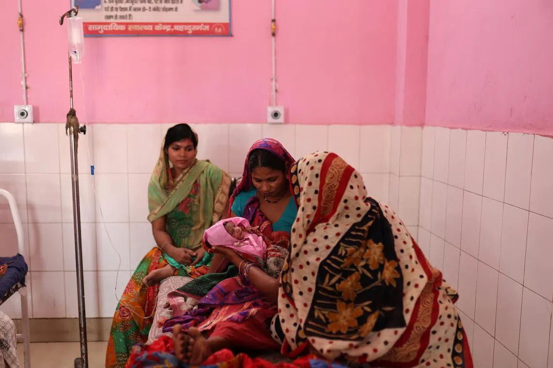 Zamerun Nisha, 33, holding her newborn baby as her sister Sanerum, 38, and her sister-in-law Zabinad, 15, keep her company at the maternity ward of a community health centre in Bahadurganj subdivision of Kishanganj district, in the state of Bihar on March 21, 2023.  "My body cannot take this pressure of having babies anymore," she told Reuters. "I have been lucky to survive each time."     