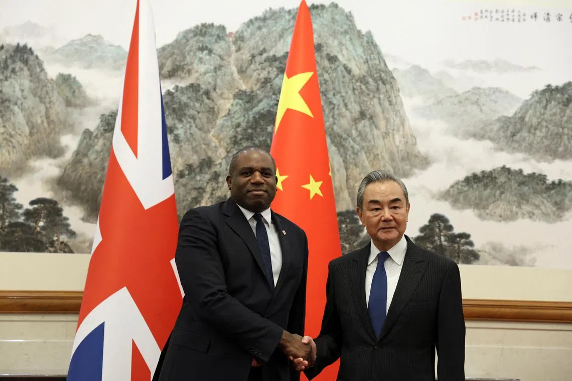 FILE PHOTO: Britain's Foreign Secretary David Lammy and Chinese Foreign Minister Wang Yi shake hands before their meeting at the Diaoyutai State Guesthouse in Beijing, China October 18, 2024. REUTERS/Florence Lo/Pool/File Photo
