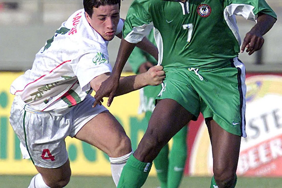 Nigeria striker Finidi George fighting for the ball with Algeria's Kraouch Nasseredine in their Africa Cup of  Nations match in Mali's capital Bamako on Jan 21, 2002.