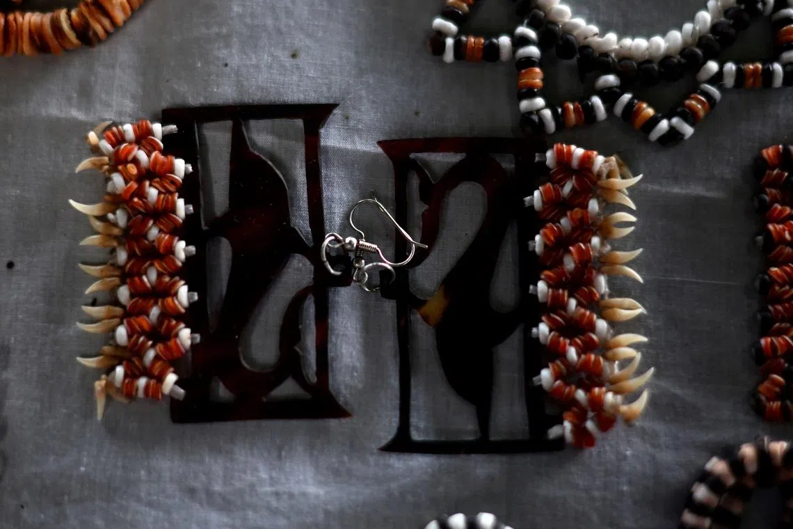 This picture taken on April 20, 2024 shows local jewellery made using dolphin teeth, renowned throughout the Solomon Islands, at a stall in the Central Market in Honiara. The Pacific's Solomon Islands has become a key player in the global live animal trade, with foreign collectors sourcing exotic species including some subject to trade bans, an AFP investigation has found. (Photo by Saeed KHAN / AFP) / To go with AFP story: Solomons-conservation-environment-animal, INVESTIGATION by Steven TRASK