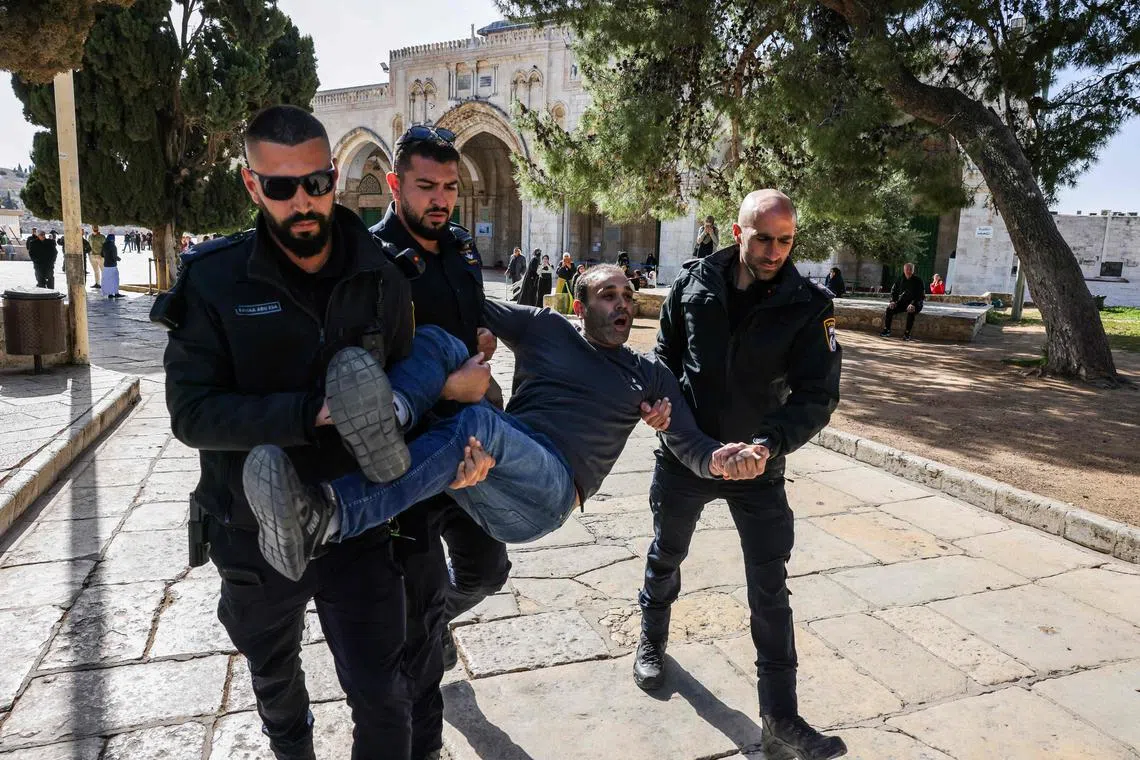 Israeli police detain a Palestinian man at the Al-Aqsa Mosque compound, following clashes.