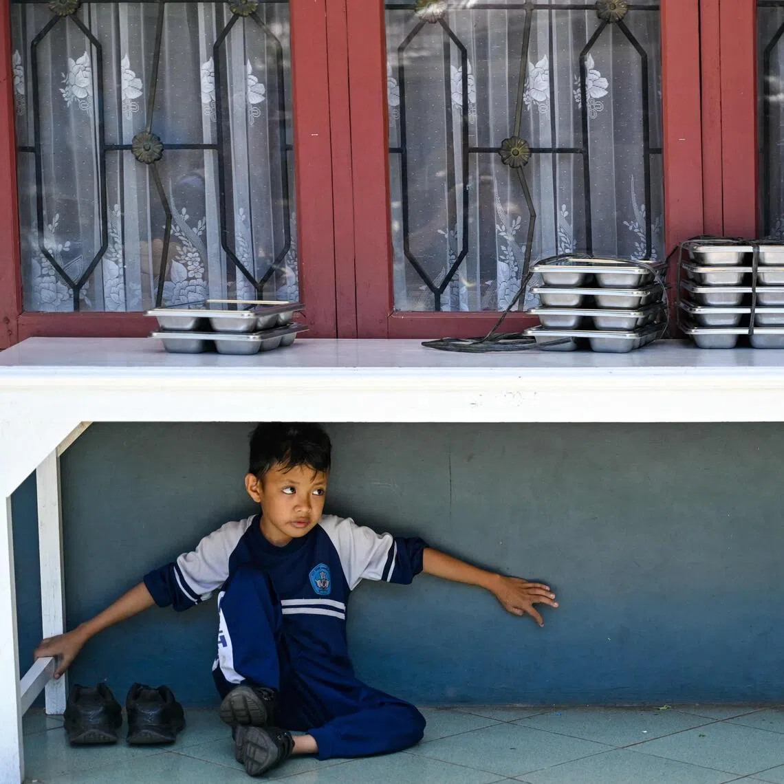 A student waits to eat food supplied by the Indonesian government's free meal programme at an elementary school in Banda Aceh, on Oct 30. 