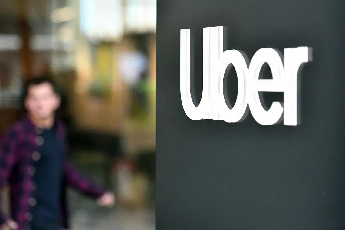 (FILES) An Uber logo is seen on a sign outside the company's headquarters location as people protest nearby in San Francisco, California on May 8, 2019. Dutch regulator hits Uber with 290-mn-euro fine over driver data transfer. (Photo by Josh Edelson / AFP)