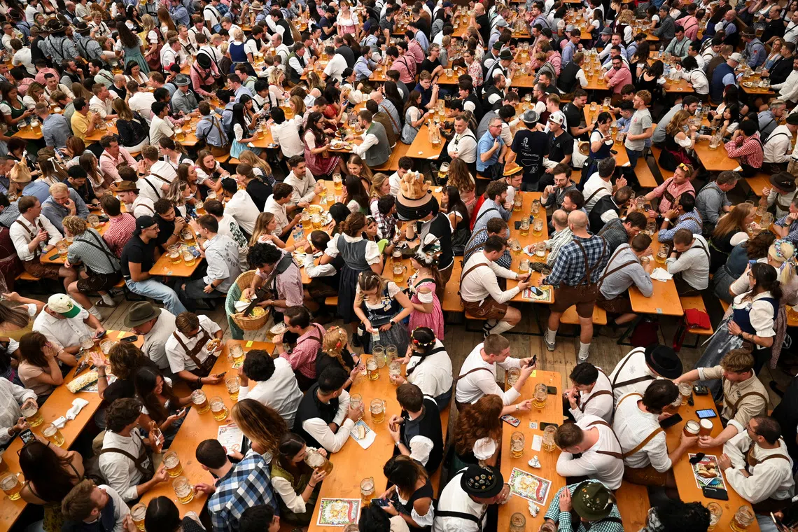 A crowd of attendees sits behind tables drinking beer during the official opening day of the 191st Oktoberfest, the world's largest beer festival, at the Lowenbrau festival tent, in Munich, Germany, September 19, 2026. REUTERS/Fariha Farooqui