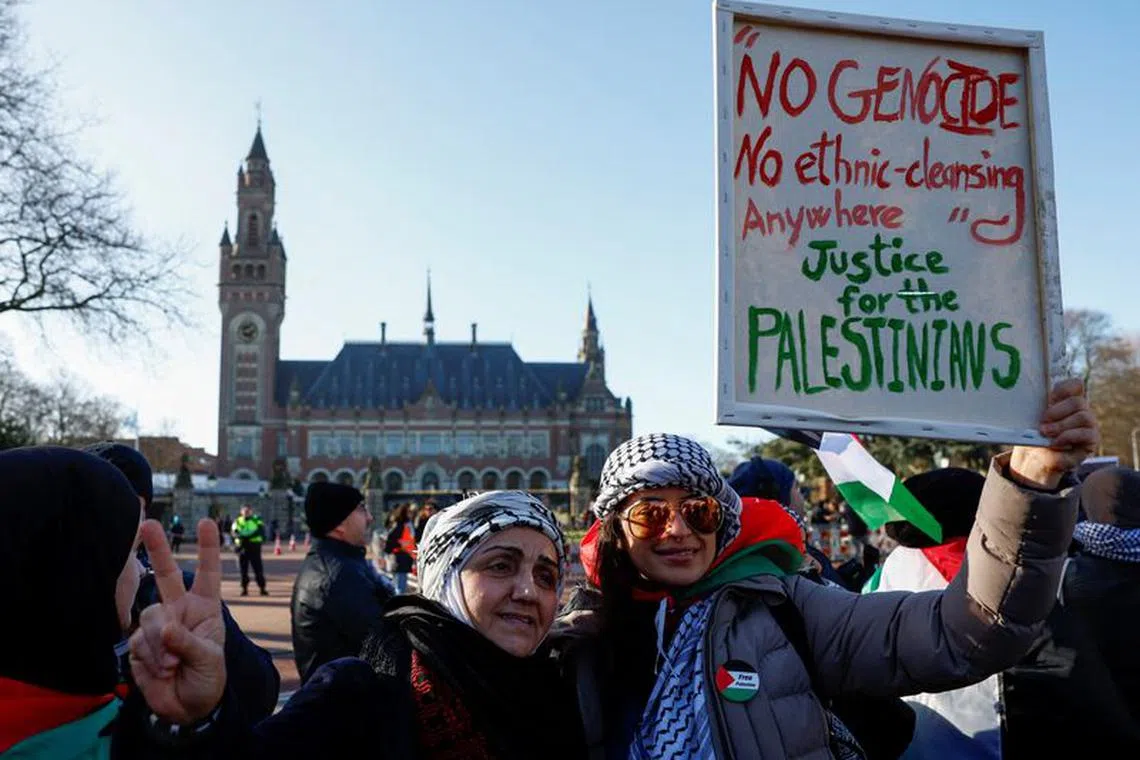 Pro-Palestinian protesters pose for a photo in front of the International Court of Justice (ICJ) as judges rule on emergency measures against Israel following accusations by South Africa that the Israeli military operation in Gaza is a state-led genocide, in The Hague, Netherlands, January 26, 2024. REUTERS/Piroschka van de Wouw