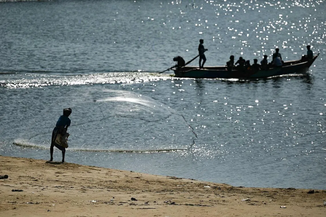 A fisherman casts his net along the confluence of Adyar river and Indian Ocean at the Srinivasapuram beach in Chennai on February 12, 2024. (Photo by R.Satish BABU / AFP)