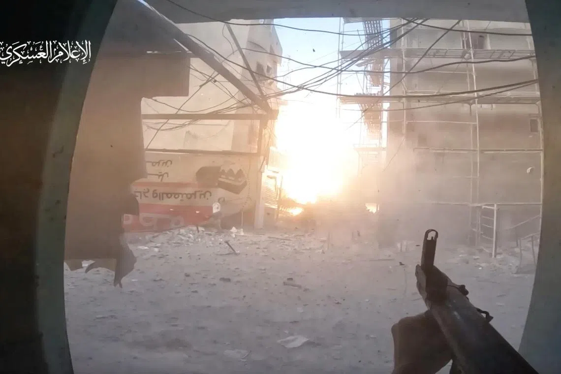 A Hamas fighter fires at an Israeli military vehicle in a Gaza Strip location that is said to be Rafah, in a video screenshot.