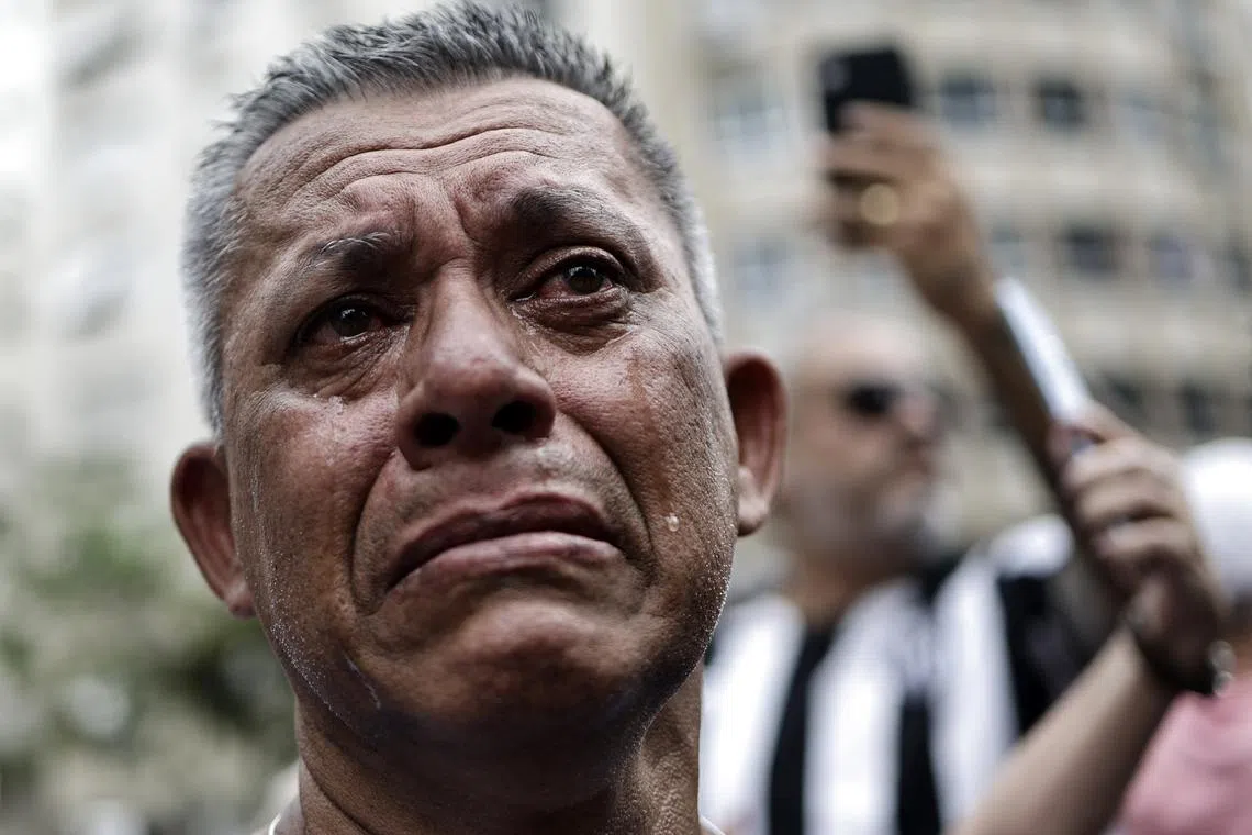 A man tears as the casket of Brazilian soccer legend Pele is transported to its final resting place, Jan 3, 2023. 