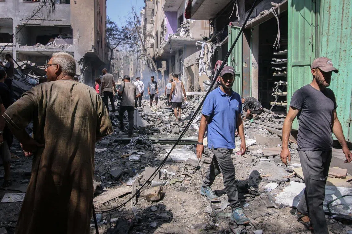 Palestinians at the site of an Israeli strike on buildings in al-Nuseirat refugee camp, in central Gaza, on June 8, 2024.