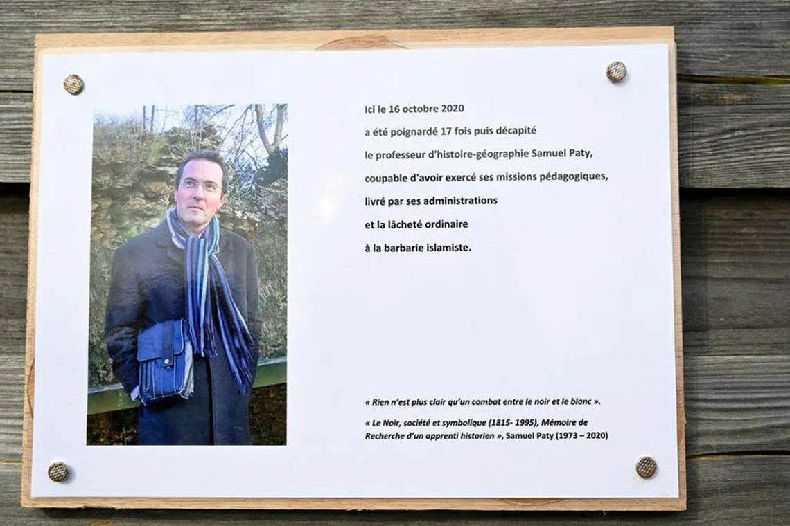 FILE PHOTO: A photograph taken on October 16, 2023 shows a commemorative plaque for slain teacher Samuel Paty (portrait) near the Bois d'Aulne school in Conflans-Sainte-Honorine, outside Paris.  BERTRAND GUAY/Pool via REUTERS/File Photo