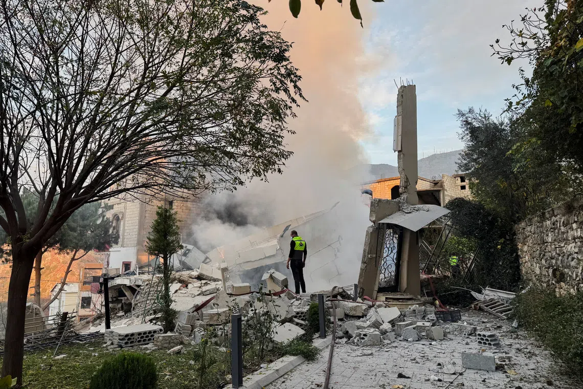 A civil defence member stands on rubble at a damaged site after Israel's military said it struck targets in two southern Lebanese towns on Thursday, in Jbaa southern Lebanon, December 4, 2025. REUTERS/Ali Hankir