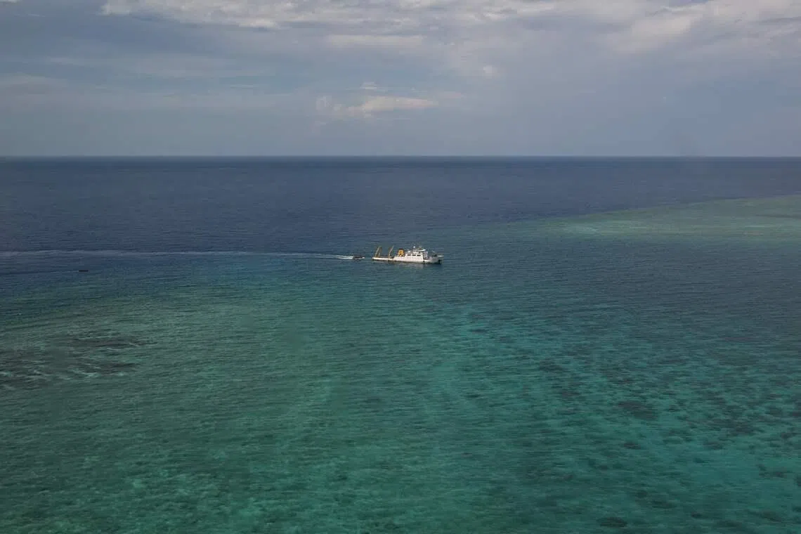 A ship identified by the Philippine Coast Guard as a Chinese research vessel is seen towing a floating structure at the mouth of Scarborough Shoal in the disputed South China Sea on June 15, 2026. (Photo by Jam STA ROSA / AFP)