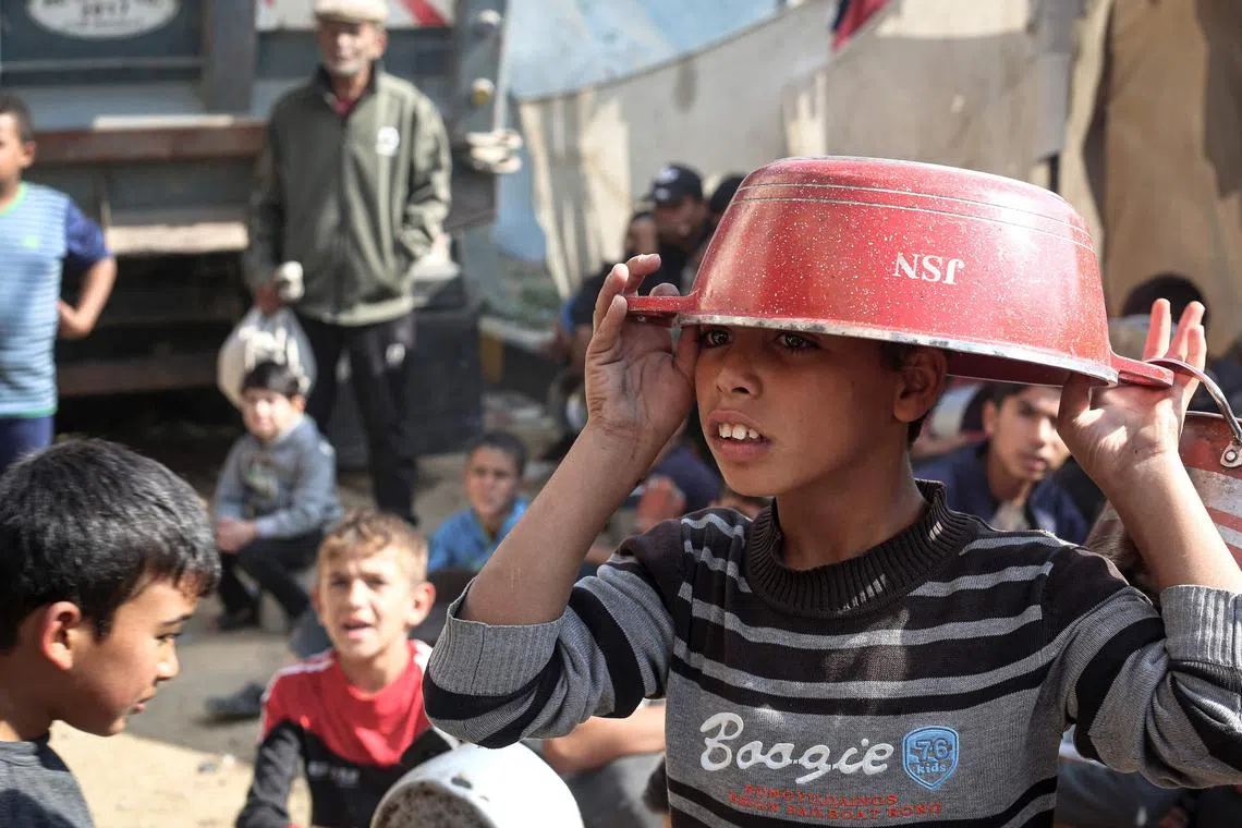 Children gathering to receive food aid, at Bureij refugee camp in the central Gaza Strip, on Nov 6.