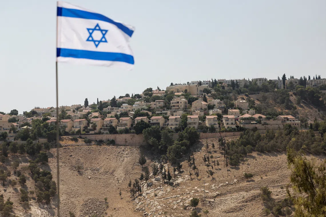 An Israeli flag flutters, as part of the Israeli settlement of Maale Adumim is visible in the background, in the Israeli-occupied West Bank, August 14, 2025. REUTERS/Ronen Zvulun/File Photo