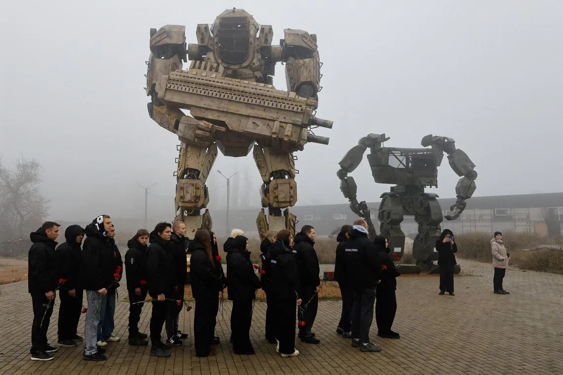 Participants hold flowers during a ceremony commemorating members of the Berkut riot police unit who were killed during the Ukrainian pro-European Union (EU) mass demonstrations in Kyiv, on the 12th anniversary of the start of the protests, in Donetsk, a Russian-controlled city of Ukraine, November 21, 2025. REUTERS/Alexander Ermochenko     TPX IMAGES OF THE DAY     
